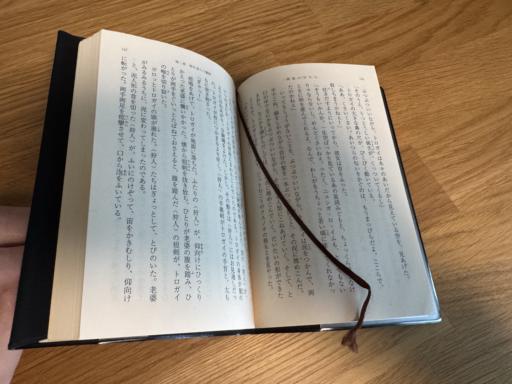 An open book with a bookmark string hanging over the page.